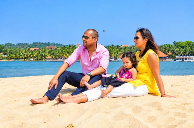 Family sitting on Poovar golden sand beach
