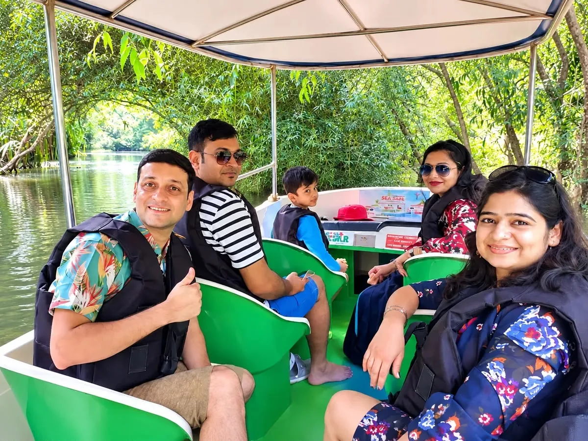 Family smiling on a Poovar boat cruise through the mangroves